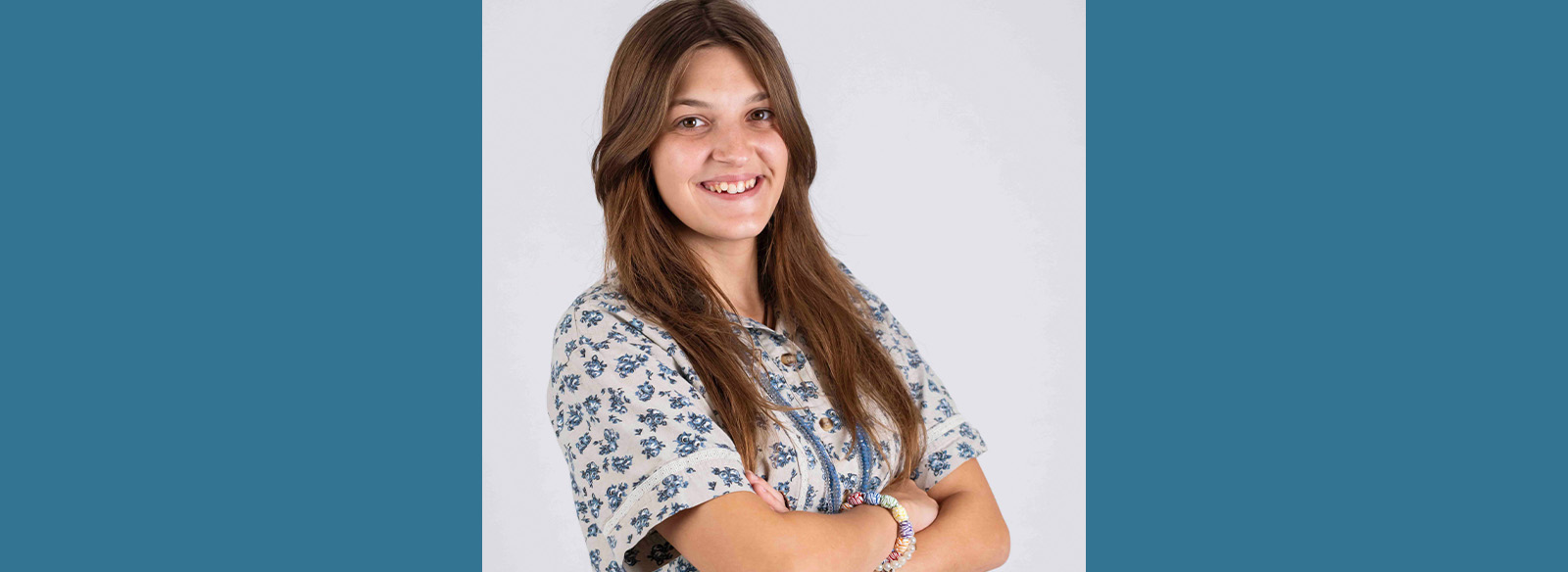 Student, Zoie Moore stands in front of a white backdrop