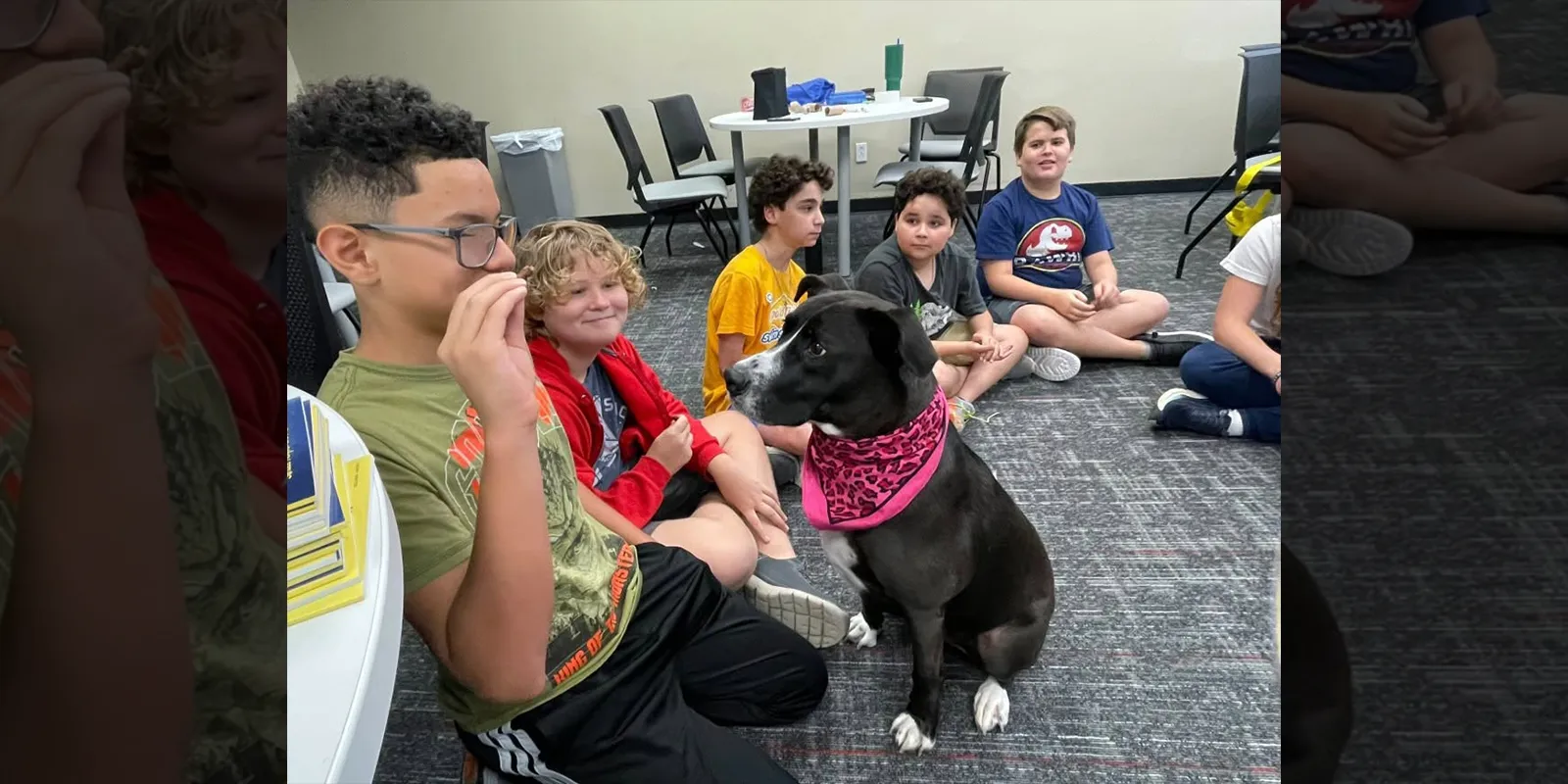 A student holds a treat for a dog as part of the heroes Kids at College class.
