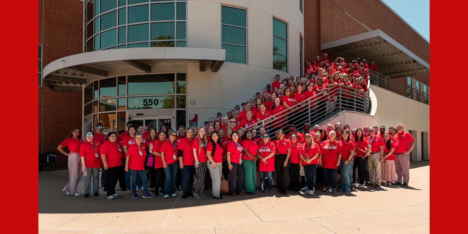 Lee College employees wear red shirts in front of the sports arena on main campus.