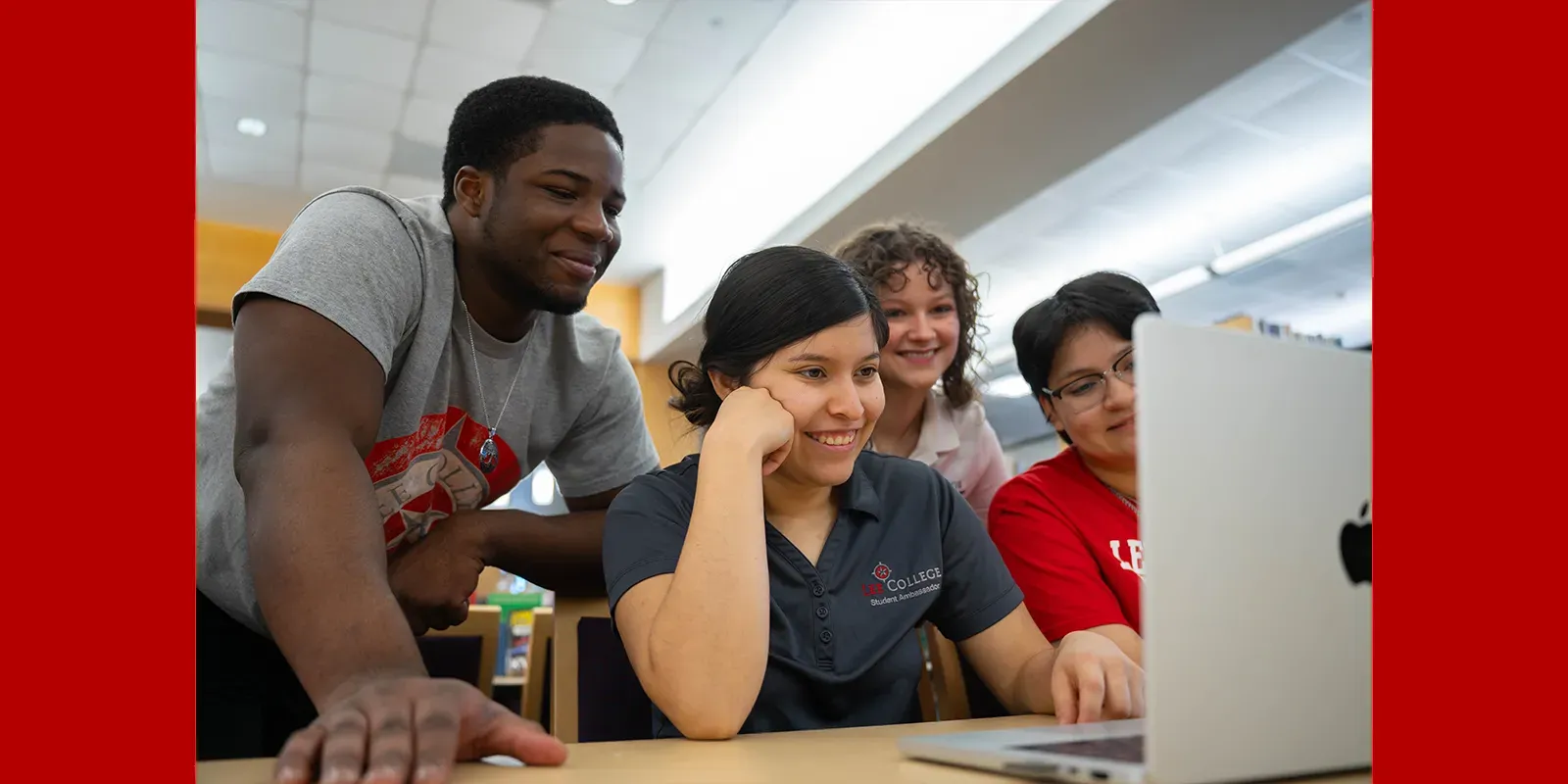 Students gathered around a laptop 
