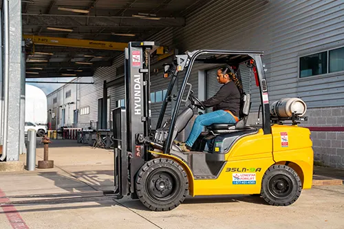 A woman drives a forklift