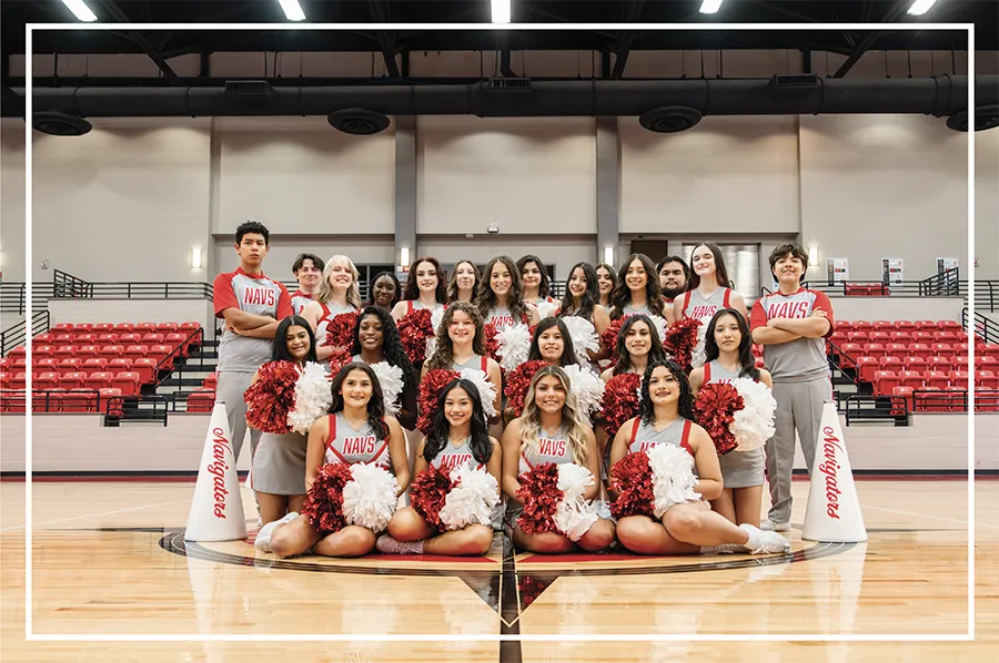 Posed photo of the entire cheer team wearing uniforms in the arena