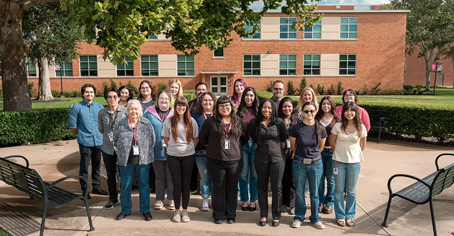 The staff members and tutors pose for a photo outdoors.